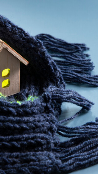 Scarf wrapped around small wooden toy home