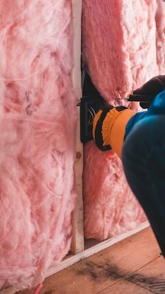 Tradesperson placing insulation inside a home through the great british insulation scheme
